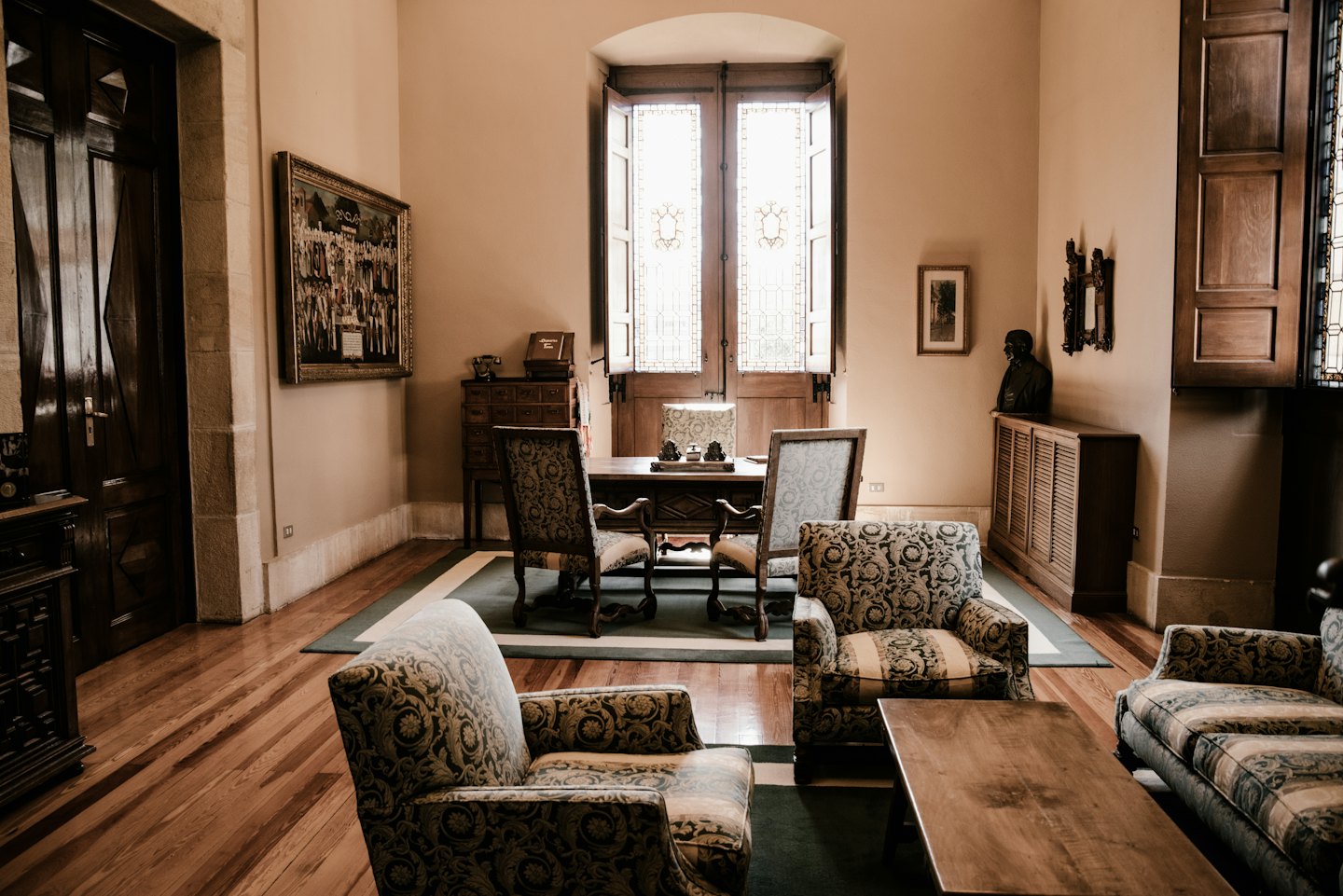 Estudio elegante con escritorio de madera y ventana arqueada.