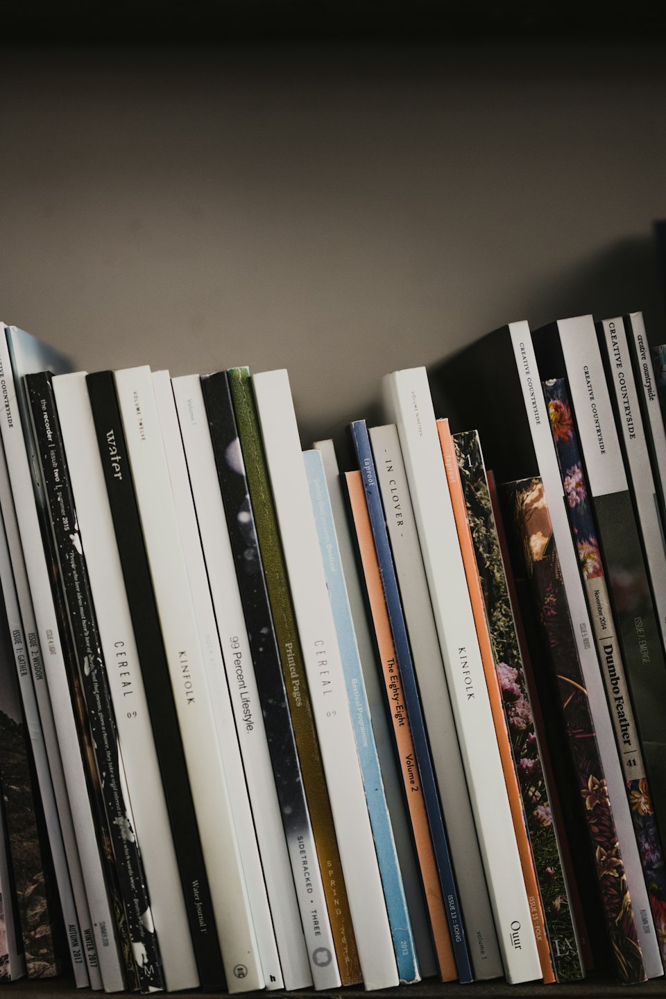 Revistas de diseño y estilo de vida apoyadas en una estantería.